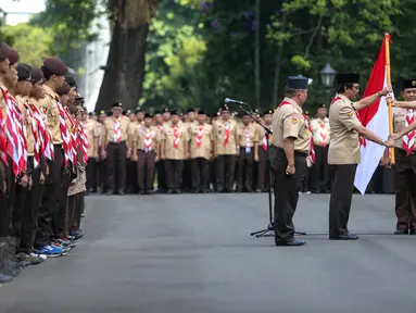 Presiden Jokowi (kanan) menyerahkan bendera merah putih kepada Ketua Kwarnas Gerakan Pramuka Adhyaksa Dault saat pelepasan 462 kontingen Pramuka Indonesia yang akan mengikuti Jambore Pramuka Dunia ke-23, Jakarta, Jumat (24/7). (Liputan6.com/Faizal Fanani)