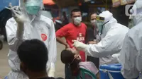 Petugas medis melakukan swab tes Covid-19 pemilik kios di pasar Perumnas Klender, Jakarta, Jumat (29/5/2020). Sebanyak, 50 pedagang pasar menjalani Rapid Test dan Swab Test untuk kedua kalinya yang mana sudah dilakukan sebelumnya ada hasil reaktif lima orang pedagang pasar. (merdeka.com/Imam Buhori)