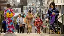 Sejumlah wanita memakai pakaian tradisional berjalan di sepanjang jalan perbelanjaan Yanaka Ginza di pusat Tokyo (30/9/2019). Wilayah Yanaka di ibukota Jepang dikenal sebagai salah satu yang paling kuno dan unik. (AFP Photo/Odd Andersen)