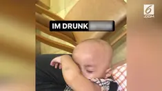 Seorang bapak dalam sebuah rekaman terlihat memberi bayinya minum dengan botol bir.