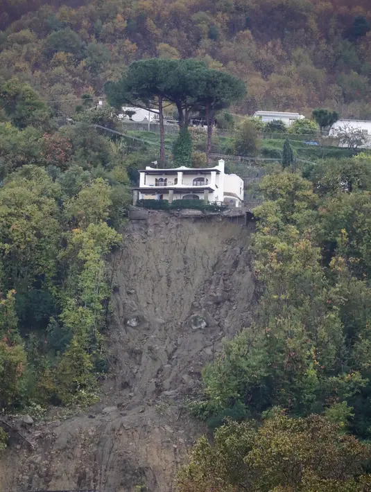 Sebuah rumah terlihat di atas tanah longsor saat hujan deras memicu tanah longsor yang meruntuhkan bangunan dan menyebabkan sebanyak 12 orang hilang, di Casamicciola, di pulau Ischia, Italia selatan, Sabtu, 26 November 2022. Petugas pemadam kebakaran sedang melakukan upaya penyelamatan karena bala bantuan sedang dikirim dari Napoli terdekat, tetapi mengalami kesulitan dalam mencapai pulau baik dengan perahu motor atau helikopter karena cuaca. (AP Photo/Salvatore Laporta)