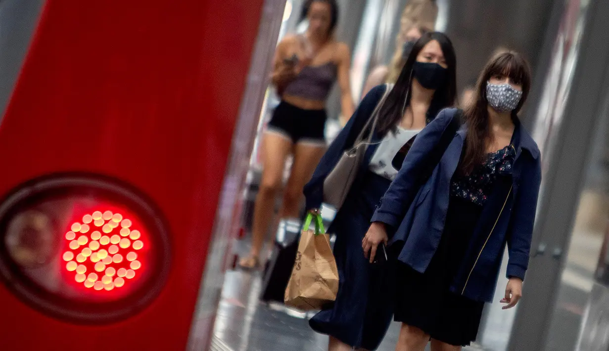Penumpang berjalan di sepanjang peron di stasiun kereta utama di Frankfurt, Jerman, Jumat (14/8/2020). Mengenakan masker untuk melindungi diri dari corona Covid-19 adalah kewajiban di transportasi umum di Jerman. (AP Photo/Michael Probst)