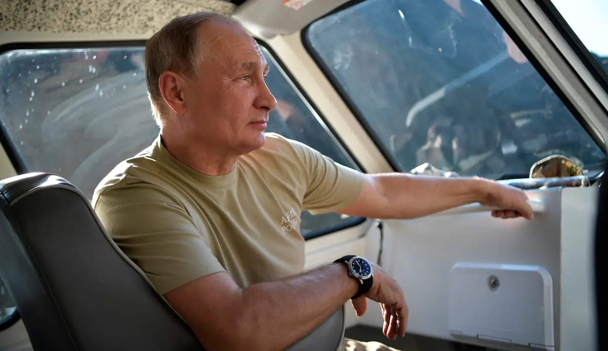 Dalam foto yang diambil pada  25 Agustus 2018, memperlihatkan Presiden Rusia Vladimir Putin duduk di dalam sebuah perahu di sungai Yenisey saat liburan singkatnya di Tuva daerah terpencil di Siberia selatan. (Alexei Nikolsky/Sputnik, Kremlin Pool via AP)