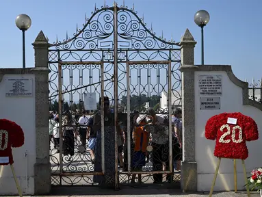 Karangan bunga berbentuk jersey sepak bola dipajang di pintu masuk pemakaman seusai upacara pemakaman penyerang Liverpool asal Portugal, Diogo Jota, dan saudaranya, Andre Silva, di Gondomar, pinggiran Porto, pada 5 Juli 2025. (MIGUEL RIOPA/AFP)