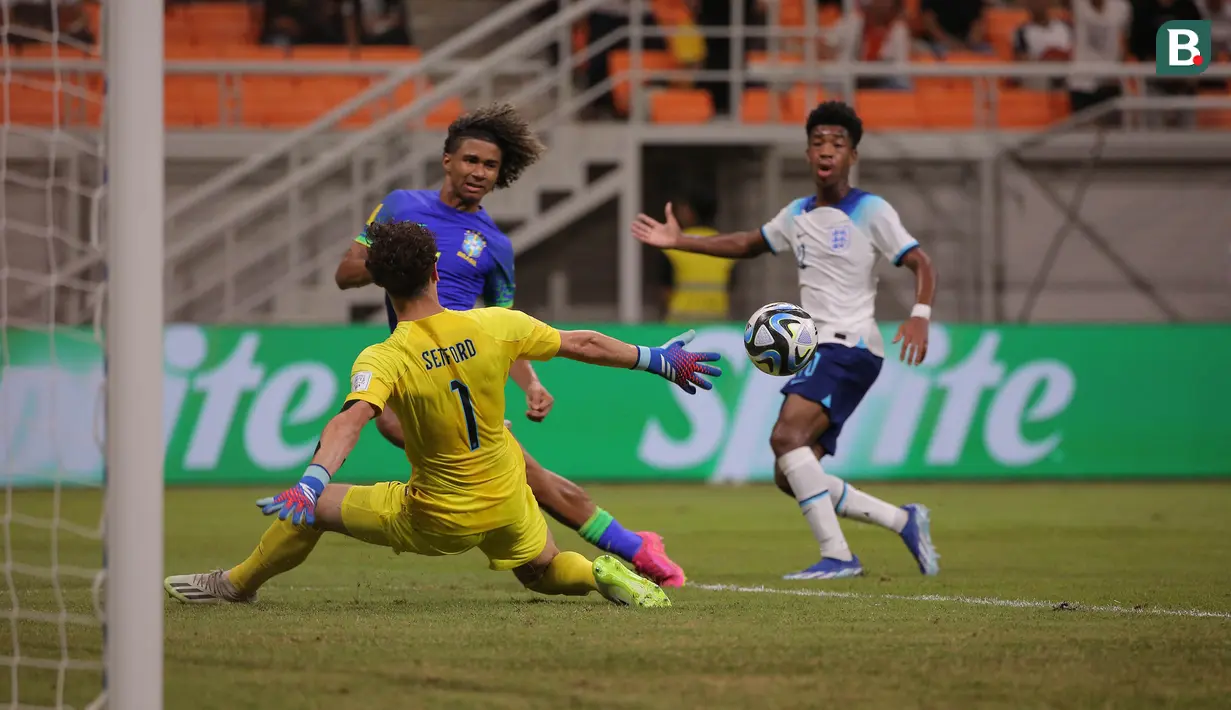<p>Pemain Timnas Brasil U-17, Pedro Lima (tengah) melepaskan umpan yang berusaha dipotong kiper Timnas Inggris U-17, Tommy Setford pada laga ketiga Grup C Piala Dunia U-17 2023 di Jakarta International Stadium, Jakarta Utara, Jumat (17/11/2023). (Bola.com/Ikhwan Yanuar)</p>