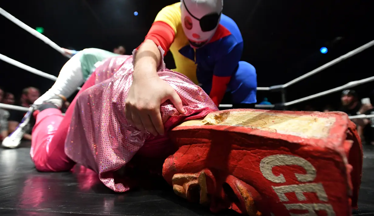 Pegulat Giggles bertanding melawan Man Cereal (bawah) saat pertandingan gulat Hoodslam di Oakland, California (7/7). Pertandingan ini menampilkan pegulat dengan karekater yang lebih aneh. (AFP Photo/Josh Edelson)