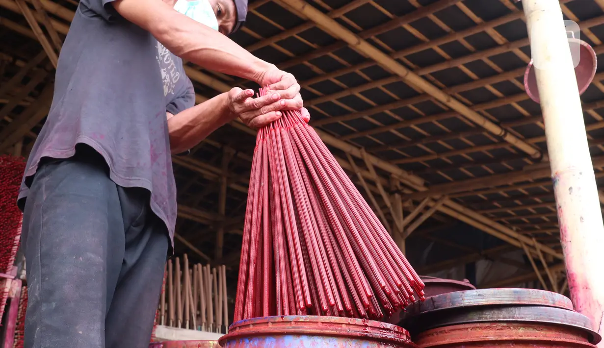 Perajin mengecat hio ketika proses pembuatan di kawasan Tangerang, Banten, Kamis (28/1/2021). Menjelang Imlek atau Tahun Baru China, permintaan akan Hio terus mengalami peningkatan untuk kebutuhan sembahyang warga keturunan Tionghoa. (Liputan6.com/Angga Yuniar)