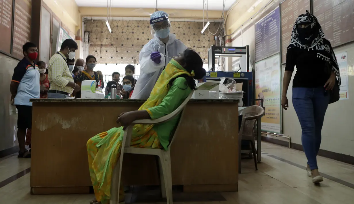 Seorang petugas kesehatan mengumpulkan sampel usap untuk diuji COVID-19 di Mumbai, India, Selasa (20/4/2021). India pada Selasa (20/4) melaporkan 259.170 infeksi baru dan 1.761 kematian akibat Covid-19 dalam 24 jam terakhir. (AP Photo/Rajanish Kakade)