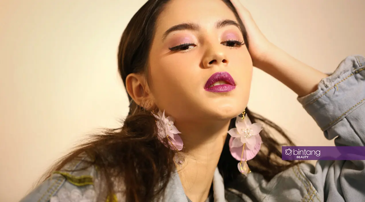 Bubuhkan eye shadow warna ungu muda serta lipstick ungu gelap yang edgy yet flattering.