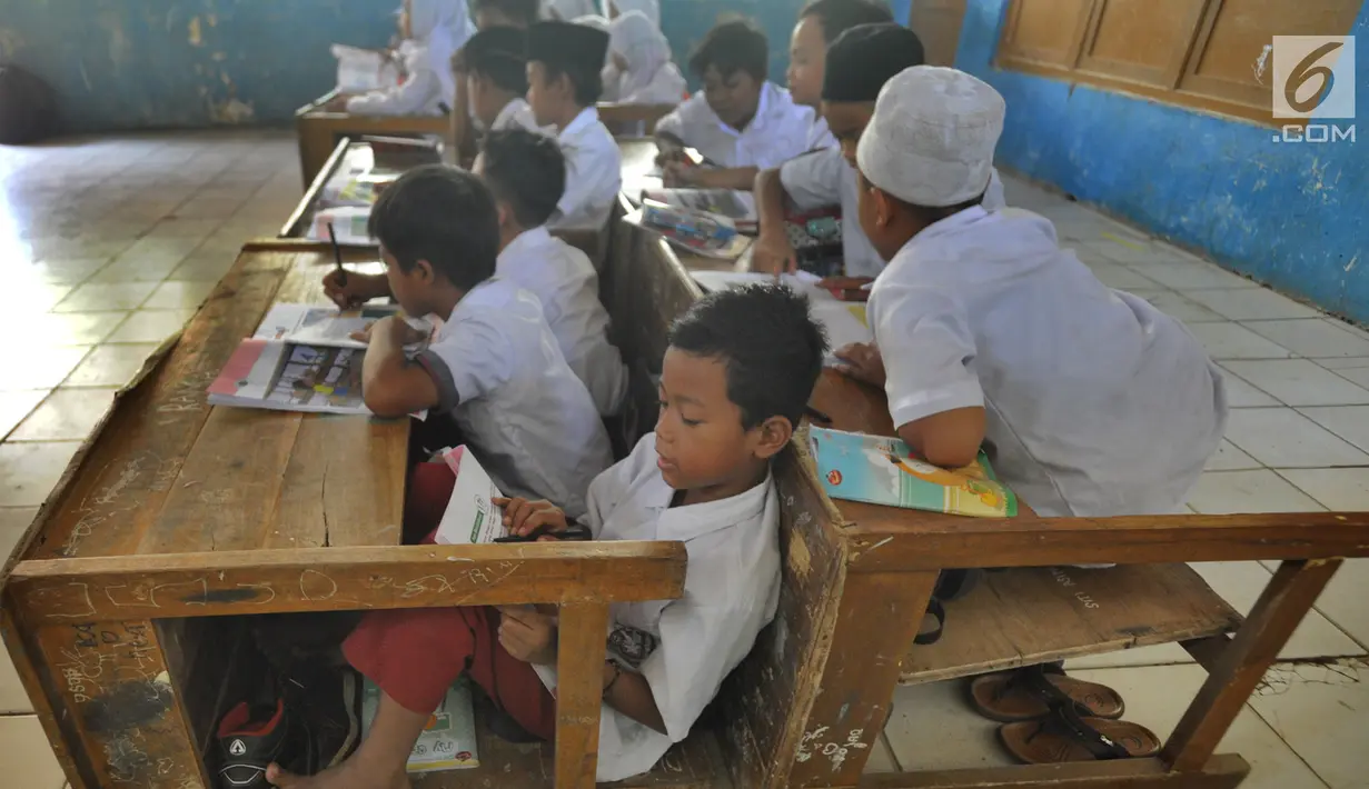 Murid-murid kelas V melakukan kegiatan belajar pada meja yang diubah menjadi kursi dan tempat belajar di SDN Kertajaya 2, Rumpin, Bogor (22/7/2019). Sekolah dengan jumlah 280 murid  dan hanya berjarak sekitar 50 km dari ibukota ini tidak dilengkapi WC dan perpustakaan. (merdeka.com/Arie Basuki)