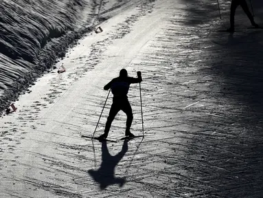 Seorang atlet melakukan pemanasan di lintasan bersalju dalam kejuaraan Nordic Combined World Cup di Austria. (Foto: AP/Matthias Schrader)