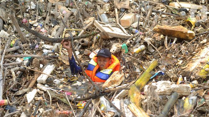 Petugas gabungan membersihkan tumpukan sampah yang menyumbat aliran air Sungai Cikeas di kawasan Bendung Koja Jatiasih, Bekasi, Jawa Barat, Rabu (16/10/2019). Pembersihan sekitar 1.200 meter kubik sampah bambu tersebut diperkirakan menghabiskan waktu dua minggu. (merdeka.com/Arie Basuki)