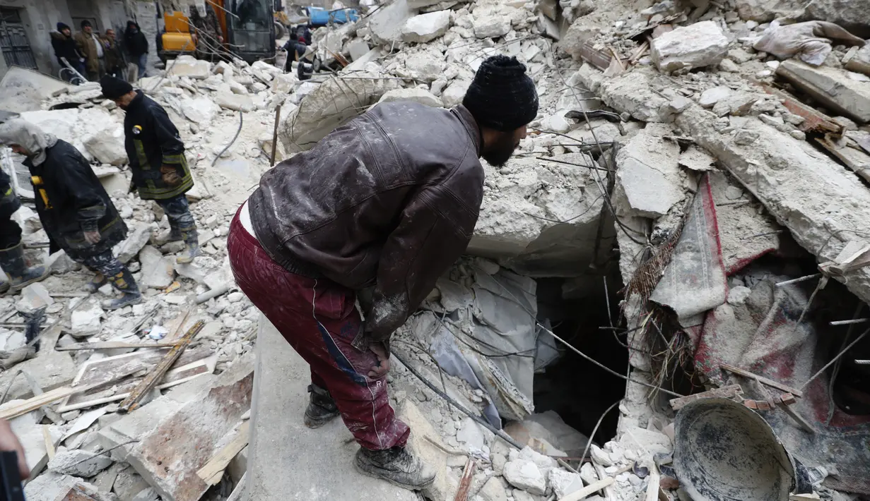 Petugas Pertahanan Sipil Suriah dan pasukan keamanan mencari korban gempa melalui puing-puing bangunan yang runtuh, di Aleppo, Suriah, Senin, 6 Februari 2023. Gempa bumi dahsyat mengguncang wilayah luas Turki dan negara tetangga Suriah pada Senin, merobohkan ratusan bangunan serta menewaskan dan melukai ribuan orang. (AP/Omar Sanadiki)