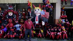 Seorang penjual pinata berdiri di depan dagangannya sebelum perayaan tradisional, Pembakaran Iblis di Guatemala City, Guatemala (7/12). Pinata adalah permainan yang biasanya ditujukan untuk anak-anak kecil saat merayakan pesta. (Reuters/Luis Echeverria)