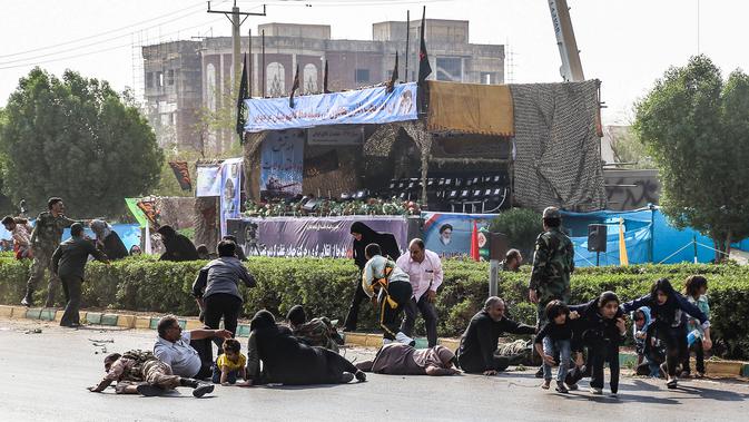 Pria, wanita, dan anak-anak tergeletak saat terjadi serangan pada parade militer di Kota Ahvaz, Iran, Sabtu (22/9). Sejumlah pria bersenjata menembaki tentara dan pejabat Garda Revolusi saat parade militer berlangsung. (MORTEZA JABERIAN/ISNA/AFP)