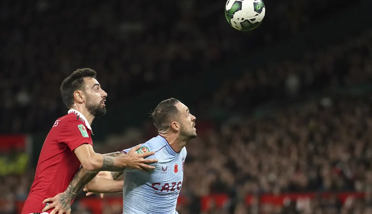 Penyerang Aston Villa, Danny Ings berebut bola dengan gelandang Manchester United, Bruno Fernandes pada pertandingan putaran ketiga Piala Liga Inggris 2022 di Stadion Old Traffodr, Manchester, Inggris, Jumat (11/11/2022). MU menang atas Aston Villa dengan skor 4-2. (AP Photo/Dave Thompson)