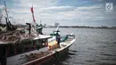 Nelayan memperbaiki jaring di Pelabuhan Muara Angke, Jakarta, Kamis (27/12). Sebagian nelayan yang biasa beroperasi di perairan dangkal masih melaut. (Liputan6.com/Faizal Fanani)
