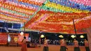 Umat Buddha mengenakan masker membawa lampion untuk merayakan ulang tahun Buddha yang akan datang pada 19 Mei di kuil Jogye, Seoul, Korea Selatan (6/5/2021). Warna-warni lampion dipasanga untuk merayakan ulang tahun Buddha yang akan datang pada 19 Mei. (AP Photo/Lee Jin-man)