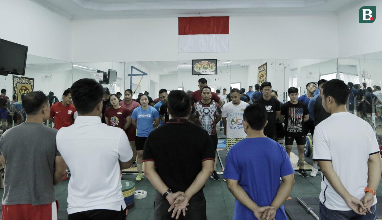 Pelatih dan atlet angkat besi melakukan doa bersama sebelum latihan di Wisma Kwini, Jakarta, Senin, (12/6/2018). Para lifter perempuan Indonesia terus melakukan persiapan jelang Asiang Games 2018. (Bola.com/M Iqbal Ichsan)
