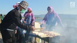 Sejumlah anggota Dharma Wanita Persatuan (DWP) membakar sate dalam memeriahkan Festival Pesona Danau Limboto, Gorontalo, Senin (24/9). MURI mencatat sebanyak 88.950 tusuk sate disajikan secara gratis oleh Pemkab Gorontalo. (Liputan6.com/Arfandi Ibrahim)