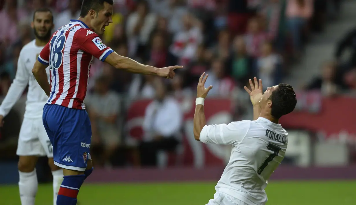  Cristiano Ronaldo berteriak setelah ditackle pemain Sporting Gijon Ismael Lopez pada lanjutan La Liga Spanyol di Stadion El Molinon, Gijon (23/8/2015).  (AFP Photo/Miguel Riopa)