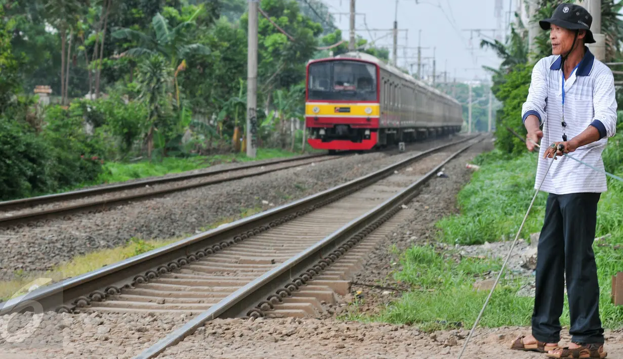 Akibat tidak adanya penjaga perlintasan kereta api, Muhamad Ali warga Pondok Cina berinisiatif untuk mejaga pos jaga perlintasan kereta api yang dibuat secara swadaya, Depok, Minggu (13/12/2015). (Liputan6.com/Yoppy Renato)