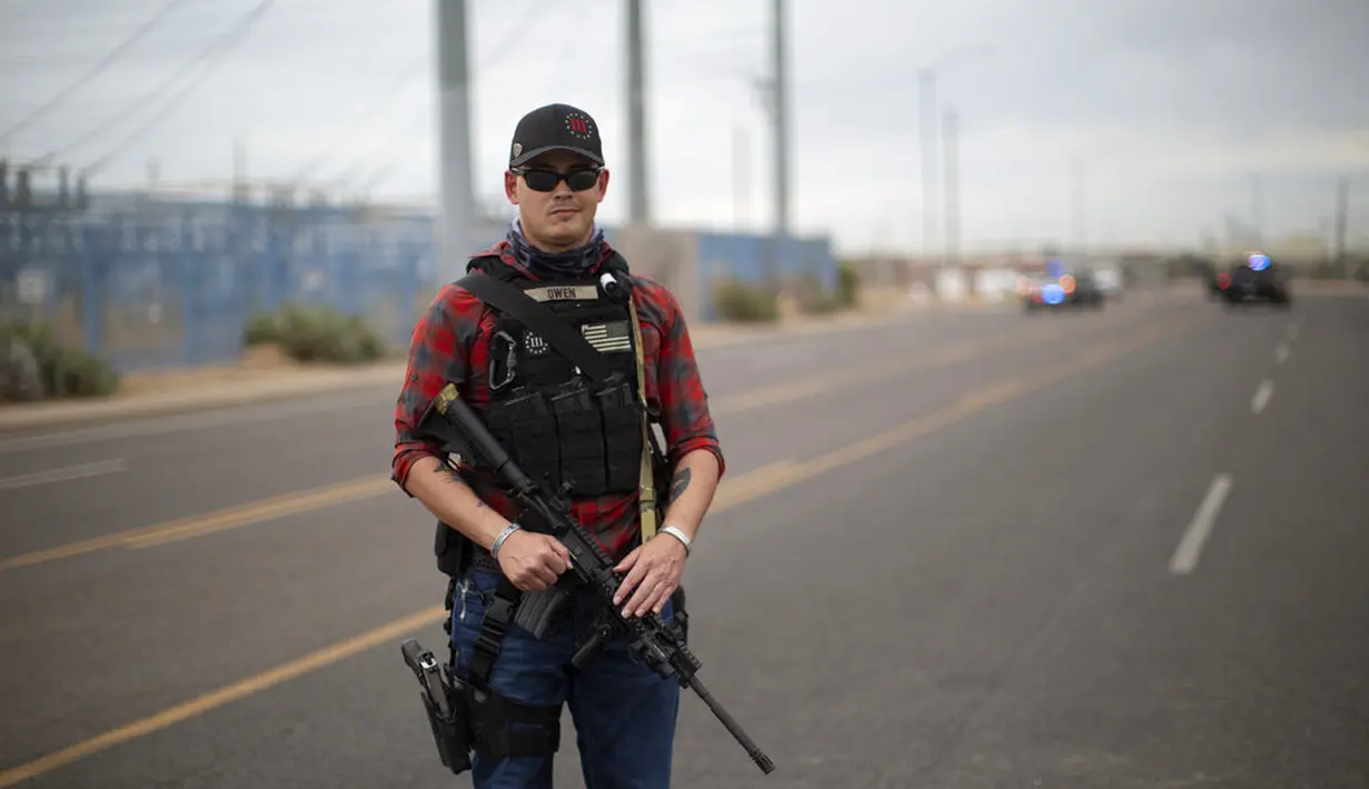 Pendukung Presiden Donald Trump, Keith membawa senjata di luar Maricopa Country Recorder's Office, Phoenix, Jumat (6/11/2020). Mantan veteran Afghanistan tersebut mengatakan dia datang bersenjata untuk melindungi protes damai. (AP Photo/Dario Lopez-MIlls)