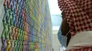 Seorang pria Saudi melihat karya seni seniman Korea Do Ho Suh di Pusat Kebudayaan Dunia King Abdulaziz, juga dikenal sebagai Ithra, di Dammam, Arab Saudi, Minggu (27/6/2021).  Pusat ini dibangun oleh Saudi Aramco dan diresmikan oleh Raja Salman pada 2016. (AP Photo/Amr Nabil)