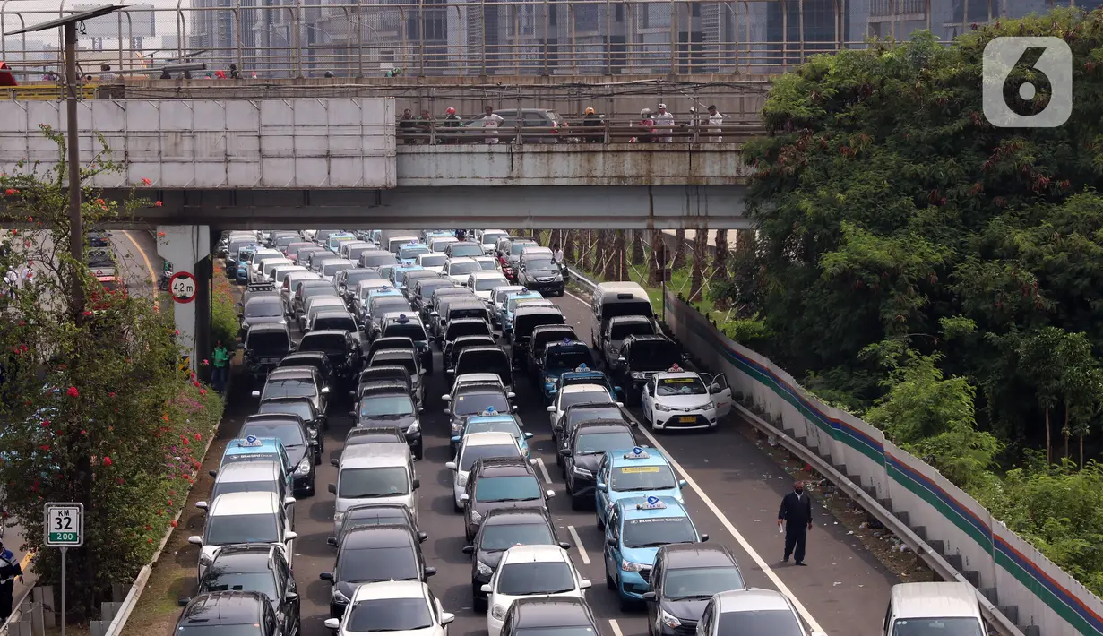 Sejumlah kendaraan terjebak kemacetan panjang di tol yang mengarah ke Bandara Soekarno-Hatta (Soetta), Tangerang, Banten, Selasa (10/11/2020). Kemacetan terjadi karena adanya penyambutan kepulangan pimipinan Front Pembela Islam (FPI) Rizieq Shihab. (Liputan6.com/Angga Yuniar)