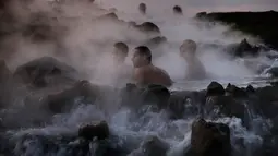 Wisatawan bersantai di kolam air panas di utara Dataran Tinggi Golan yang diduduki Israel, 4 November 2017. Air mengalir dari aliran pipa pengeboran di Lembah Hula yang merupakan upaya mengurangi kekeringan di kawasan pertanian. (ENAHEM KAHANA/AFP)