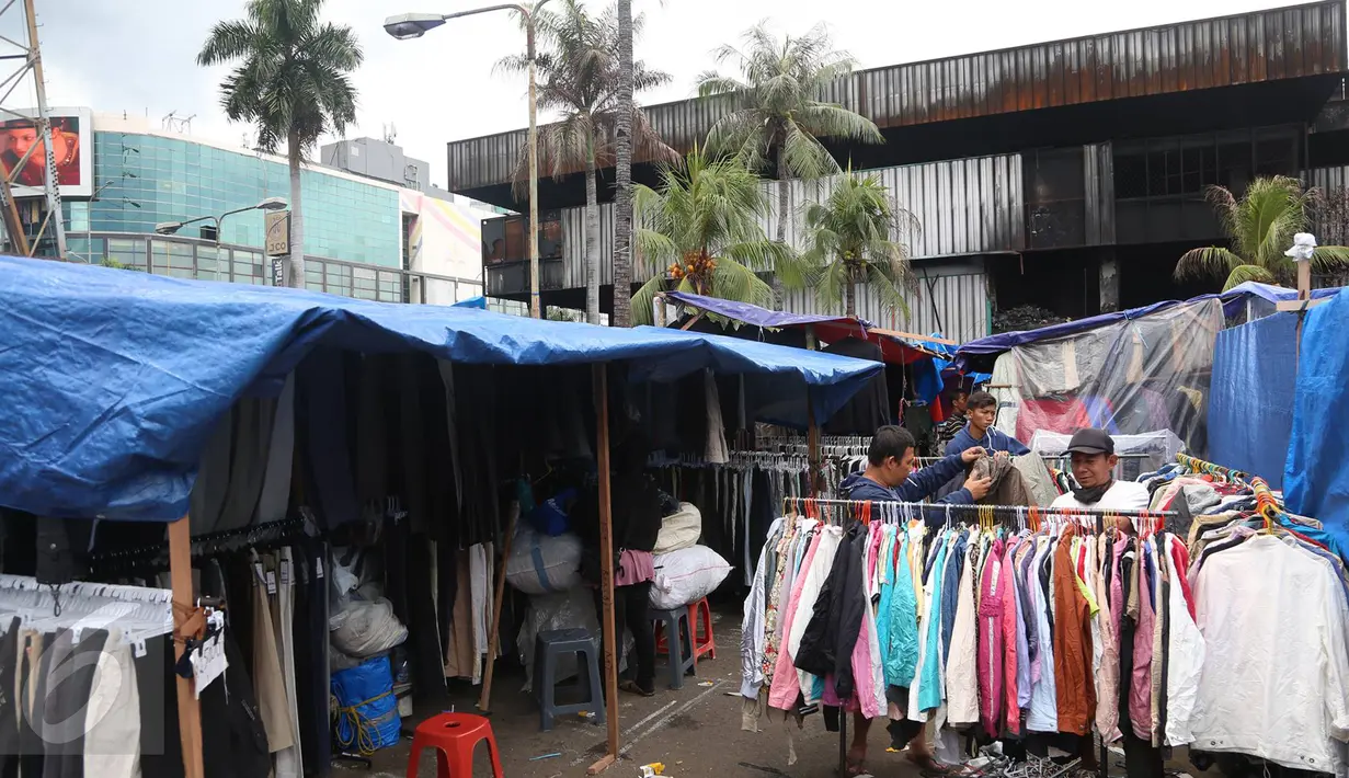 Pedagang korban kebakaran terpaksa mendirikan tenda untuk berjualan di area parkir Pasar Senen, Jakarta, Rabu (8/2). Belum tersedianya tempat penampungan sementara membuat para pedagang terpaksa mendirikan tenda lapak. (Liputan6.com/Immanuel Antonius)