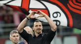 Pemain AC Milan, Zlatan Ibrahimovic, memberikan isyarat cinta kepada ribuan suporter setelah memberikan pidato perpisahannya dari dunia sepakbola di San Siro, Senin (5/6/2023) dini hari WIB. (AP Photo/Antonio Calanni)