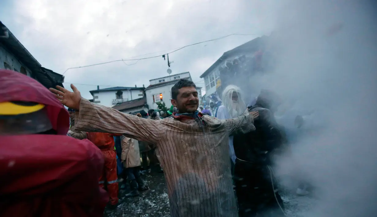 Seorang peserta berdiri menunggu dilempari tepung saat mengikuti Festival O Entroido di Laza, Spanyol, Senin (8/2). Festival yang berlangsung selama seminggu itu dianggap sebagai peristiwa sosial dan budaya utama di kota Laza. (REUTERS/ Miguel Vidal)