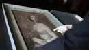 Kurator Mathieu Deldicque memegang lukisan 'Monna Vanna' atau dikenal dengan 'Mona Lisa Telanjang' di Museum Conde, Chantilly, Prancis, Senin (11/3). Para pakar memastikan lukisan tersebut diselesaikan oleh seniman kidal. (Kenzo Tribouillard/AFP)
