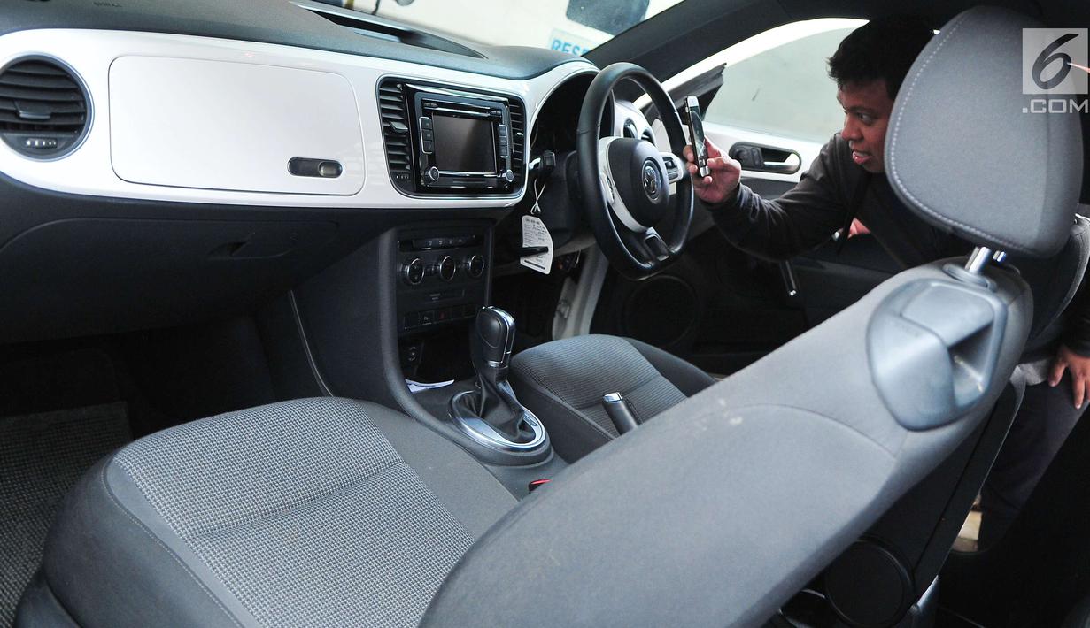 Calon peserta lelang mengambil gambar interior mobil hasil sitaan kasus korupsi di Gedung KPK, Jakarta, Selasa (19/9). KPK melelang sebanyak 19 unit mobil dari berbagai model dan merek dengan harga termurah Rp28,8 jutaan. (Liputan6.com/Helmi Afandi)