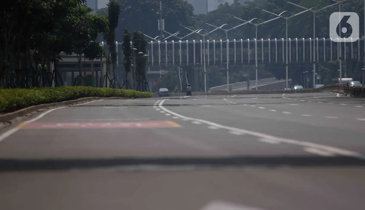 Suasana Jalan lengang di beberapa ruas jalan protokol di Jakarta, Jumat (10/4/2020). Pemerintah resmi memberlakukan PSBB setelah adanya Peraturan Pemerintah (PP) Nomor 21 Tahun 2020 dengan didukung oleh Peraturan Menteri Kesehatan (PMK) Nomor 9 Tahun 2020. (Liputan6.com/Angga Yuniar)