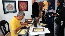 Pelukis membuat kaligrafi nama seseorang pada Festival budaya Arab Saudi, Saudi House di Resto Pulau Dua Senayan, Jakarta, Minggu (19/8). Kegiatan ini didukung Komite Olimpiade Saudi dan Otoritas Budaya Umum Saudi. (Liputan6.com/Fery Pradolo)