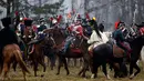 Sejumlah peserta berpakaian seperti tentara Rusia dan Prancis tahun 1812 mengunggang kuda melakukan adegan pertempuran di Belarus (26/11). Acara ini juga untuk memperingati 205 tahun perang Berezina. (AP Photo/Sergei Grits)