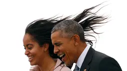Rambut Malia Obama terbang terkena angin saat dirinya dan sang ayah yang juga Presiden AS, Barrack Obama turun dari pesawat Air Force One di Bandara O'Hare, Chicago, Kamis (7/4/2016). (REUTERS/Kevin Lamarque)