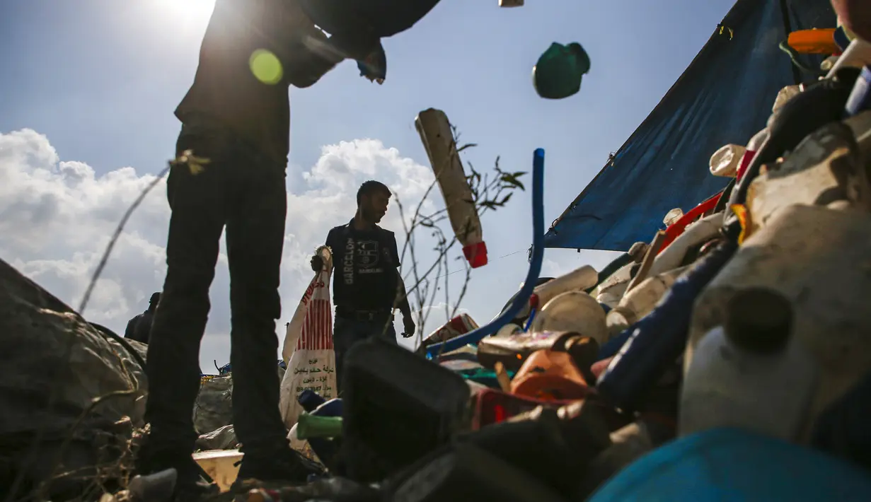 Para pengumpul sampah Palestina memisahkan sampah di tempat pembuangan sampah di Kota Gaza (29/7/2019). Kemiskinan yang terjadi akibat blokade Israel dan kurangnya kesempatan kerja membuat beberapa warga Palestina memilih bekerja mencari sampah untuk dijual. (AFP Photo/Mohammed)