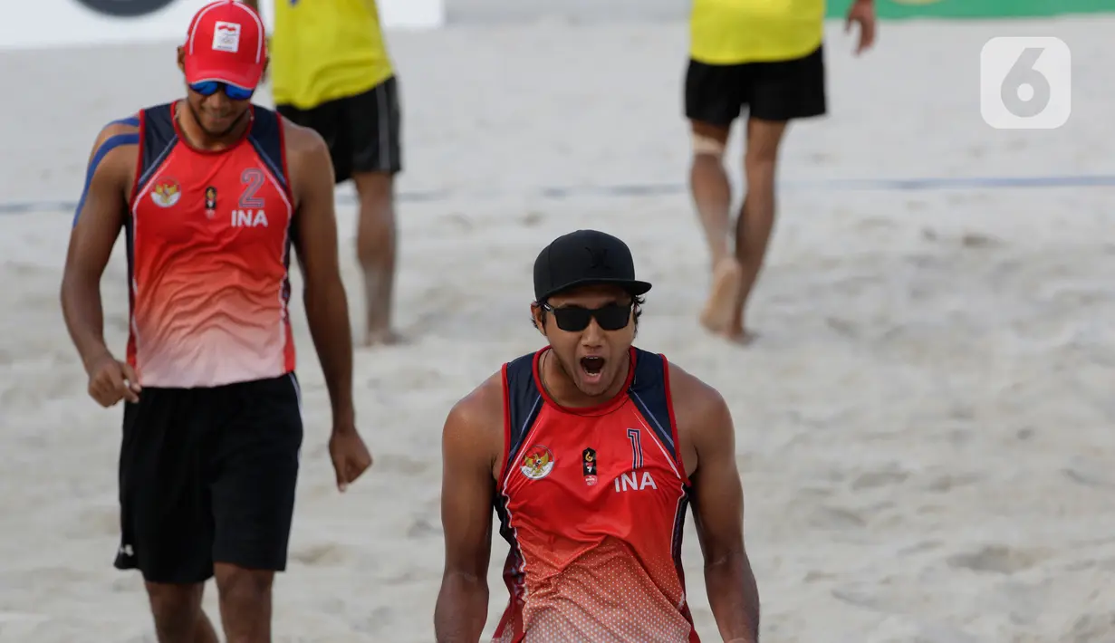Pevoli pantai Indonesia, Ade Chandra dan Muhammad Ashfiya, merayakan kemenangan atas Thailand pada laga final voli pantai beregu putra SEA Games di Subic Court Tennis, Filipina, Jumat (6/12/2019). Indonesia berhasil meraih emas. (Bola.com/M Iqbal Ichsan)