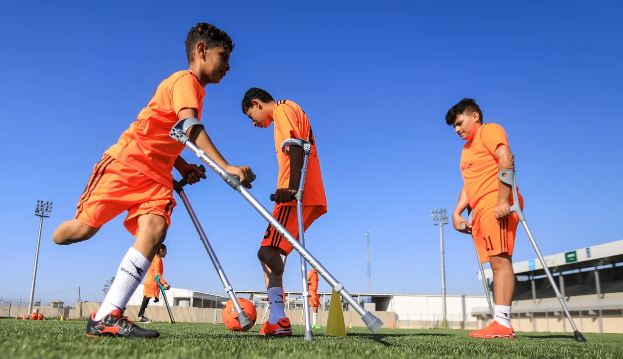 Anak-anak Palestina yang diamputasi berpartisipasi dalam sesi pelatihan sepak bola, yang diatur oleh Komite Palang Merah Internasional (ICRC) setelah pembatasan penyakit coronavirus (COVID-19) mereda, di Deir al-Balah di Jalur Gaza tengah (14/7/2020). (AFP/Mahmud Hams)