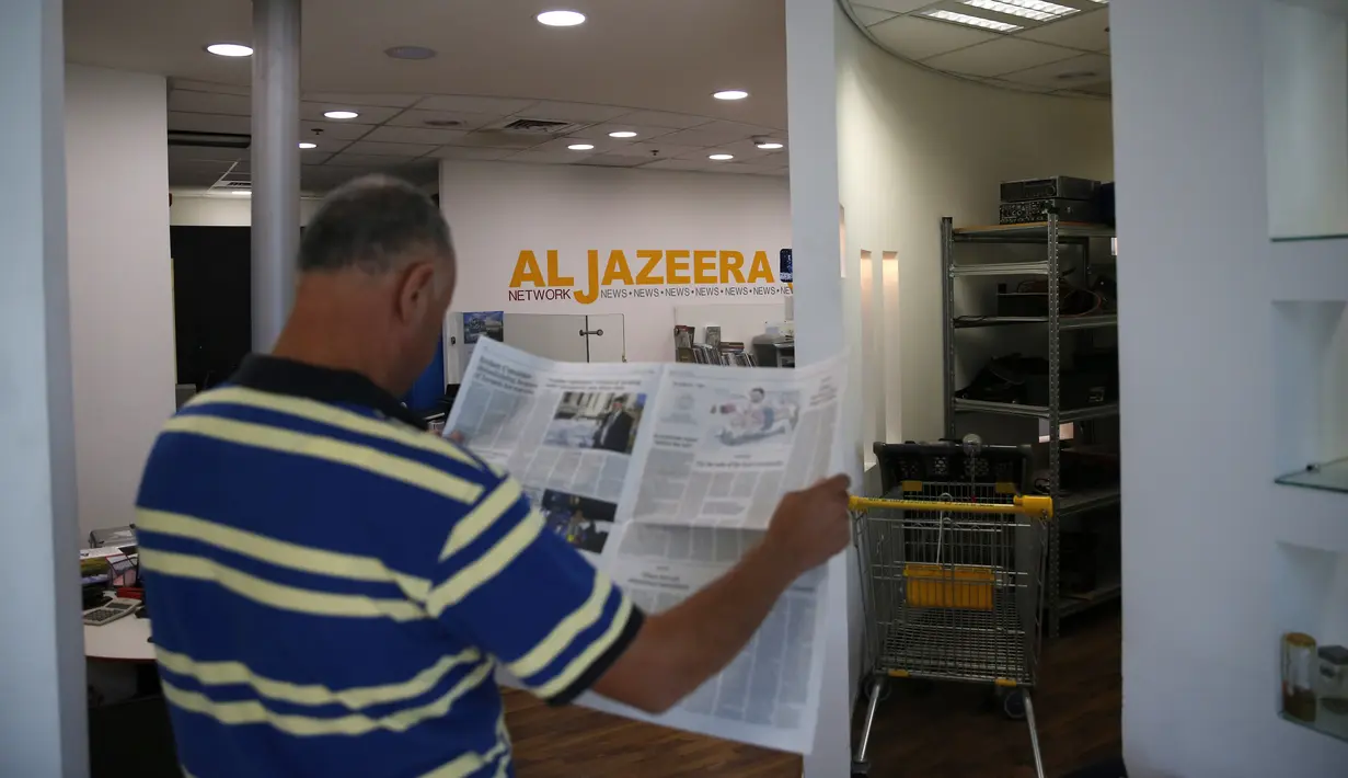 Seorang karyawan membaca koran di kantor berita Al Jazeera, Yerusalem, 31 Juli 2017. Belum jelas kapan penutupan kantor media di Yerusalem yang juga dimusuhi Arab Saudi dan negara-negara Arab lainnya itu akan dilakukan. (AHMAD GHARABLI/AFP)