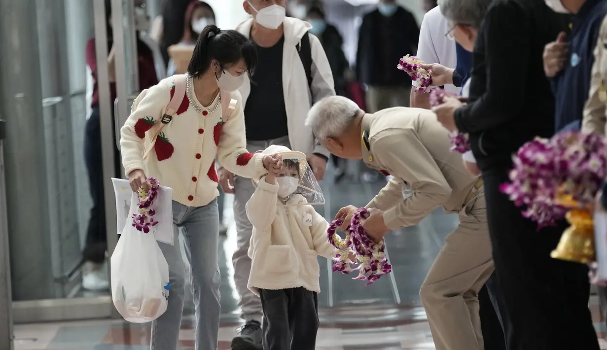 Seorang pejabat Thailand memberikan karangan bunga kepada turis China setibanya di Bandara Internasional Suvarnabhumi di provinsi Samut Prakarn, Senin (9/1/2023). Wisatawan China sekitar sepertiga dari jumlah total turis yang mengunjungi Thailand sebelum pandemi covid-19, dan pihak berwenang berharap mereka dapat membantu memulihkan industri pariwisata yang menguntungkan. (AP Photo/Sakchai Lalit)