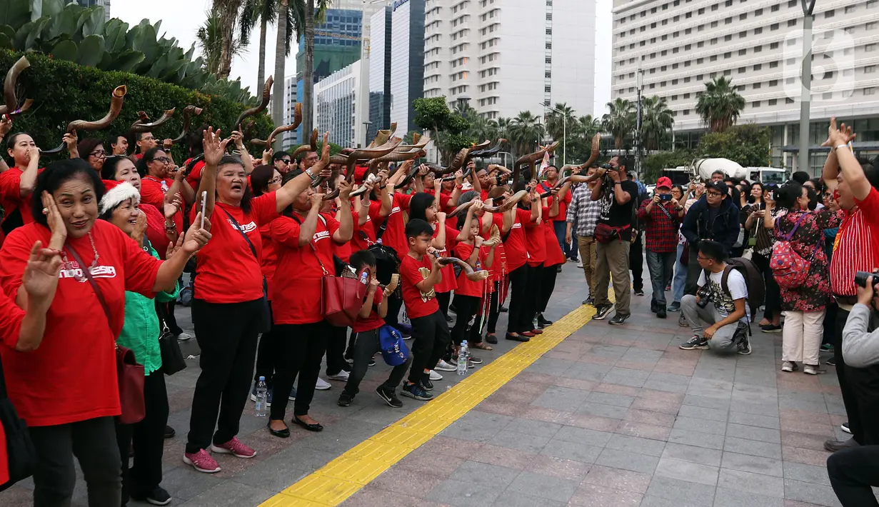 Umat Nasrani memainkan alat musik shofar saat tampil dalam acara Christmas Carol di kawasan Bunderan HI, Jakarta, Jumat (20/12/2019). Alat musik ini terbuat dari tanduk rusa Afrika, cara meniupkannnya bisa dengan nada pendek dan panjang yang memiliki makna yang berbeda. (Liputan6.com/Johan Tallo)