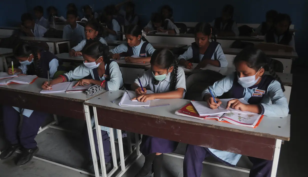 Sejumlah siswa mengenakan masker saat prose belajar mengajar di sebuah sekolah pemerintah di Hyderabad, India, Rabu (4/3/2020). (AP Photo/Mahesh Kumar A.)