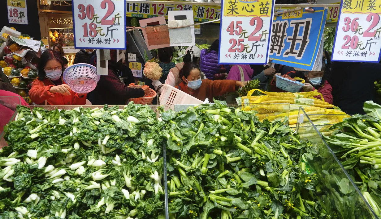 Pelanggan mengenakan masker, membeli sayuran segar di toko pasar basah di Hong Kong, Rabu, 9 Februari 2022. Hong Kong memberlakukan langkah-langkah jarak sosial yang paling ketat untuk mempertahankan kebijakan nol COVID-19 di tengah lonjakan kasus yang dipicu Varian Omicron. (AP Photo/Vincent Yu)