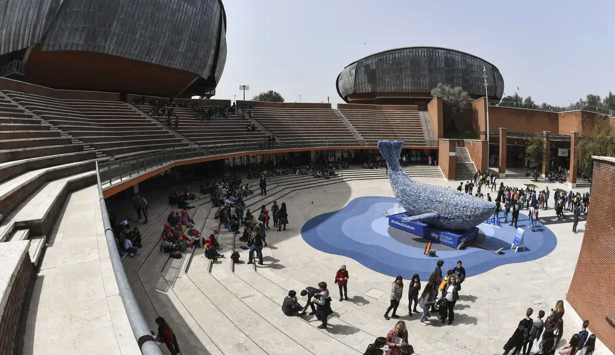 Suasana saat pengunjung melihat-lihat patung paus raksasa, Plasticus yang dipajang di depan Auditorium Parco della Musica, Roma, Italia, Senin (16/4). Berat Plasticus sesuai jumlah plastik yang masuk ke laut setiap detiknya. (Andreas SOLARO/AFP)