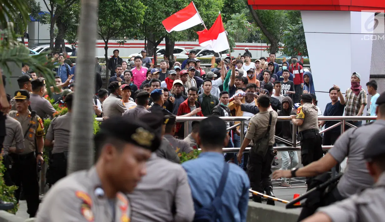 Massa aksi pendukung revisi Undang-Undang Komisi Pemberantasan Korupsi (KPK) mendatangi depan gedung lembaga antirasuah di Kuningan, Jakarta, Jumat (13/9/2019). Saat demonstrasi berlangsung, mereka membakar karangan bunga bernada dukungan dan keprihatinan terhadap KPK. (Liputan6.com/HO/Andri)