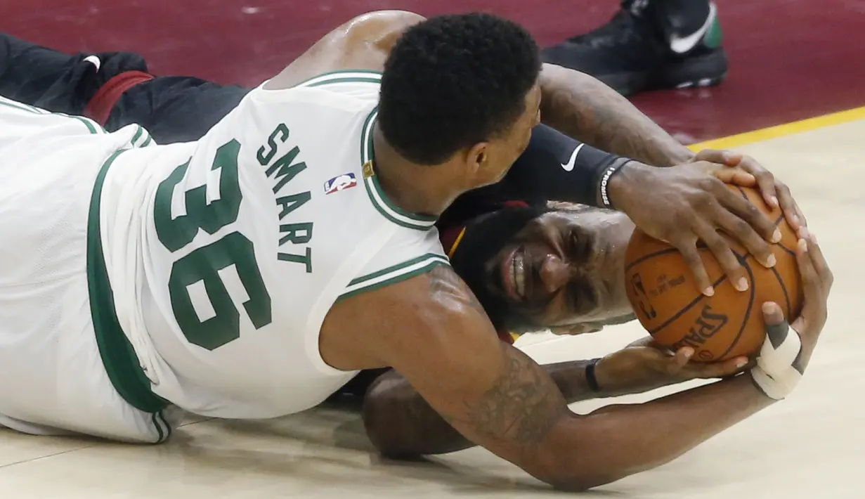 Pemain Cleveland Cavaliers, LeBron James dan pemain Boston Celtics, Marcus Smart berebut bola pada gim keenam final wilayah timur NBA basketball di Quicken Loans Arena, (25/5/2018). Cavaliers menang 109-99. (AP/Ron Schwane)